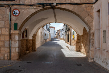 A village street with an arch at the entrance in El Toboso, Toledo province, Spain.
