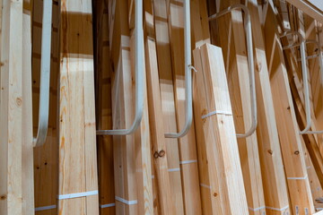 Wooden beams arranged neatly in a warehouse for construction projects during daytime hours