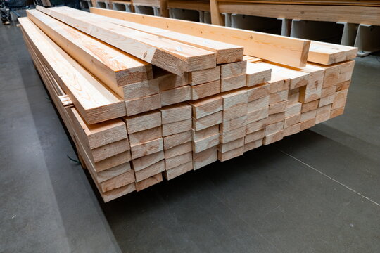 Stacked lumber ready for construction at a home improvement store in the early afternoon showcasing various sizes of wood planks