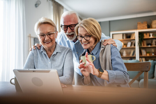 Senior friends enjoying video call with family on tablet