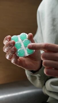 Throat lozenges for a sore throat.
A person holding a blister pack of throat lozenges.
Medicine, health, lozenge, blister, strip, pharmaceuticals