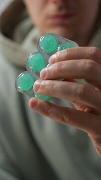 A person holding a blister pack of mint throat lozenges.
Menthol lozenges or tablets.
Sore throat relief and prevention during a sore throat.