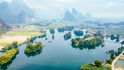 Aerial view of karst mountains surrounding rural farmland at Mingshi Village (Mingshi Tianyuan) during winter in Daxin County, Chongzuo city, Guangxi Province, China © sweetriver