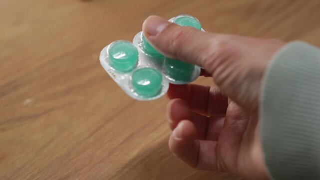 Throat lozenges for a sore throat.
A person holding a blister pack of throat lozenges.
Medicine, health, lozenge, blister, strip, pharmaceuticals