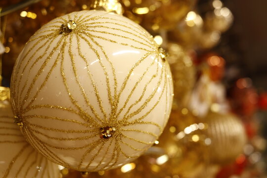 Boule de no&euml;l de couleur beige et or ronde portant des incrustations de perles dor&eacute;es, de paillettes et de dorures