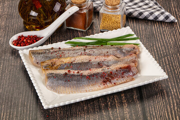 Salted marinated herring fillet with spices