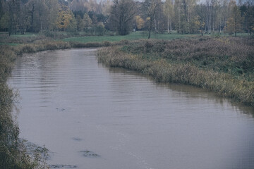 river in autumn with brown dirty water. Latvia, Vircava river