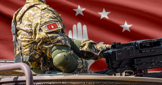 Abkhazia flag with soldier at machine gun turret in front of it. Closeup side view.