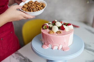 Making a cake with white and pink chocolate strawberries. High quality photo