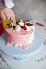 Making a cake with white and pink chocolate strawberries. High quality photo