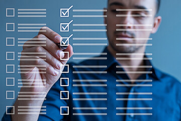 Man completing a digital checklist with a stylus marking off tasks on a virtual todo list for productivity and organization in a modern business or personal management context