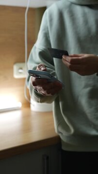 Money transfer from a bank card.
Transferring money to an e-wallet.
Topping up a mobile phone account and paying utility bills.
A person holding a phone and a credit card.