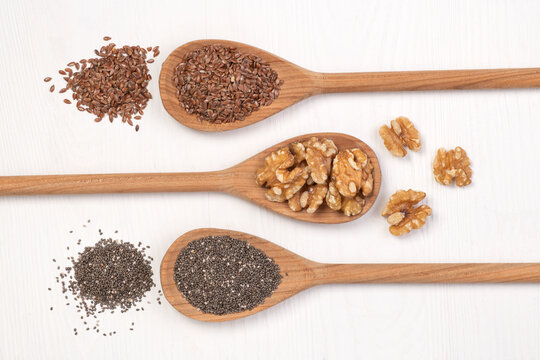 Wooden spoons with chia seeds, flax seeds and walnuts, vegan souces of omega 3 fatty acids