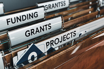 Closeup of file folders labeled funding grants grantss and projects in an office setting showcasing organization and management of financial resources and project documentation for business use