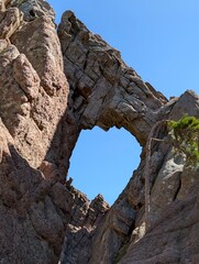 the bomb hole in the rock in the Bavella Mountains at sunshine und blue sky