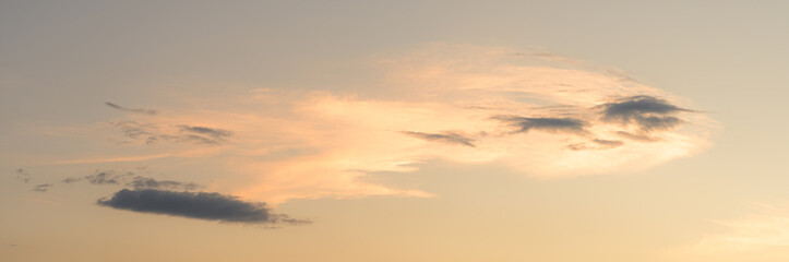 As the sun descends toward the horizon, a vibrant sunset begins to unfold, painting the sky with an array of soft, wispy cloud patterns. This stunning spectacle showcases the incredible artistry of na
