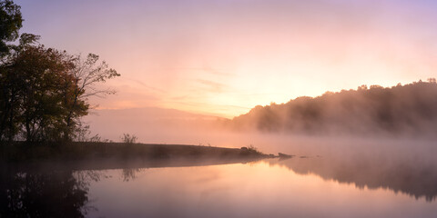 Sunrise brings a soft glow to Glen-O-Jones Lake in Southern Illinois, where gentle mist dances above the water and trees framing the shore awaken to a new day filled with promise