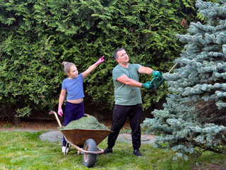 Father and daughter gardening together in the backyard