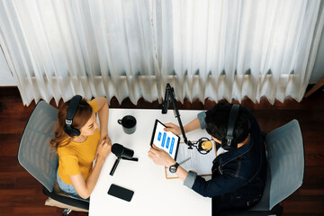Top view of smiling radio influencer hosts wearing headphone with channel social media online live...