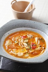 A Korean-style army stew made with willow milky mushrooms, sausage, tofu, and kimchi simmered in a spicy broth for a rich and hearty flavor. Created by Master Chef Hanshunseop. Photographed in Korea.