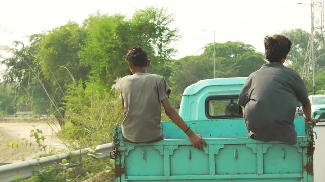 Two Boys Sitting beside Rickshaw in Indian Village Street