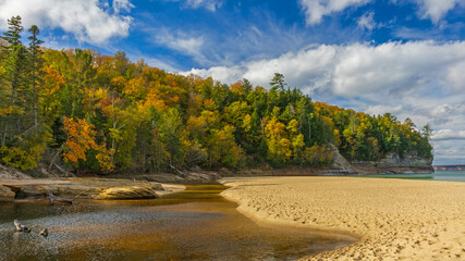 autumn landscape with river flowing into lake