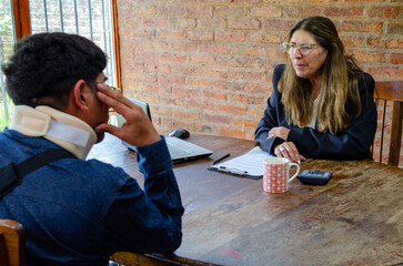 Mature adult female lawyer assist a injured man with legal problem. Lawyer showing document. Compensation for work or car accident. Legal concept. Social Worker.