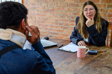 Mature adult female lawyer assist a injured man with legal problem. Lawyer showing document. Compensation for work or car accident. Legal concept. Social Worker.