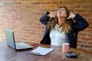 Mature woman worker suffering of pain on neck and back.Woman employee stretching in pain.