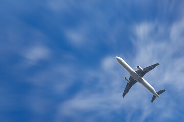 A view from below of an airliner against a background of clouds