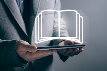 A businessman touches a book icon on the screen