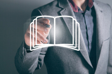 A businessman touches a book icon on the screen