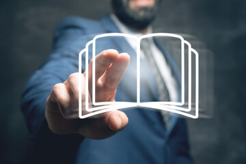 A businessman touches a book icon on the screen