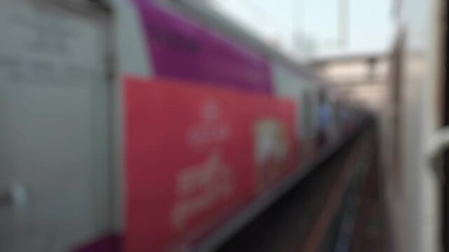 Bokeh view outside of suburban passenger train running to Mumbai, Maharashtra, India. Blurred background footage.
