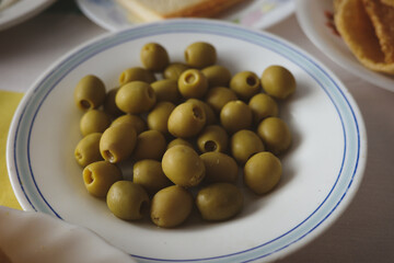 Green olives served on a white plate for appetizer