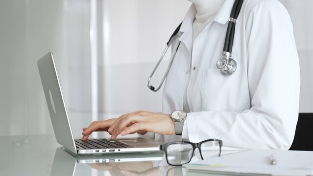 Healthcare professional working on laptop, providing digital medicine consultation and tele health service. Medicine, healthcare and science concept