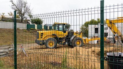 Orange bulldozer at a construction site on a cloudy day. Construction equipment moves sand