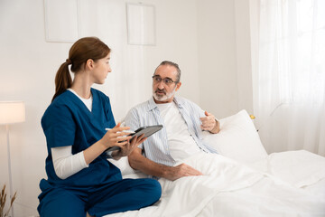 Obraz premium Home healthcare service for seniors with female nurse checking elderly man's heartbeat using stethoscope. Ideal for medical care, elder support, home visit, and heart health visuals.