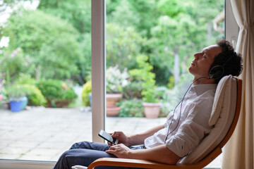 relax and listen music at home, man having rest after work, sitting in armchair and wearing headphones, alone time