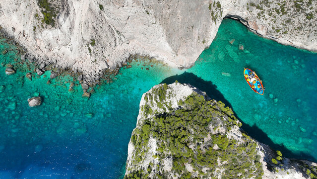 Aerial drone photo of scenic paradise bay with white rocky seascape forming small caves surrounded by limestone trees visited by small boats and yachts in tropical exotic island destination - Powered by Adobe