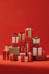 Stack of Christmas presents with ribbons on red background	
