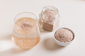 Psyllium in a glass of water, in a bowl in a jar on the table