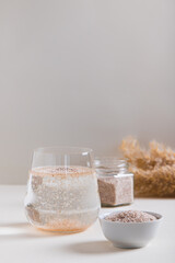 A glass of water and psyllium husk on the table for health  vertical view