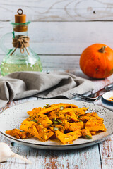 Spicy salad with fried pumpkin, garlic and herbs on a plate on the table vertical view