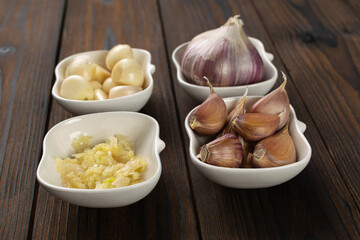 Garlic on Wooden Table: Cloves, Bulbs, and Minced Variations in Ceramic Bowls for Cooking Inspiration