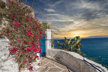 Traditional Greek house with blue door and sea view at sunset in Nafplio, Peloponnese