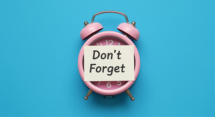 Pink alarm clock with a note that says dont forget on a blue background
