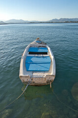 Traditional fishing boats and yachts docked at a peaceful harbor during golden sunset