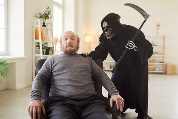 Evil old senior man who sinned and did bad things sitting in chair with scared frightened face...