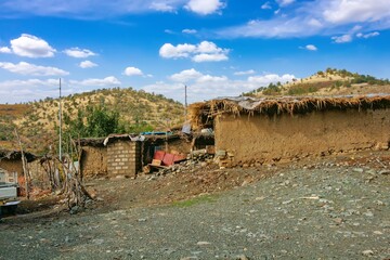 Traditional rural life in a Kurdish village, featuring a weathered stone and wood shelter and a dirt path